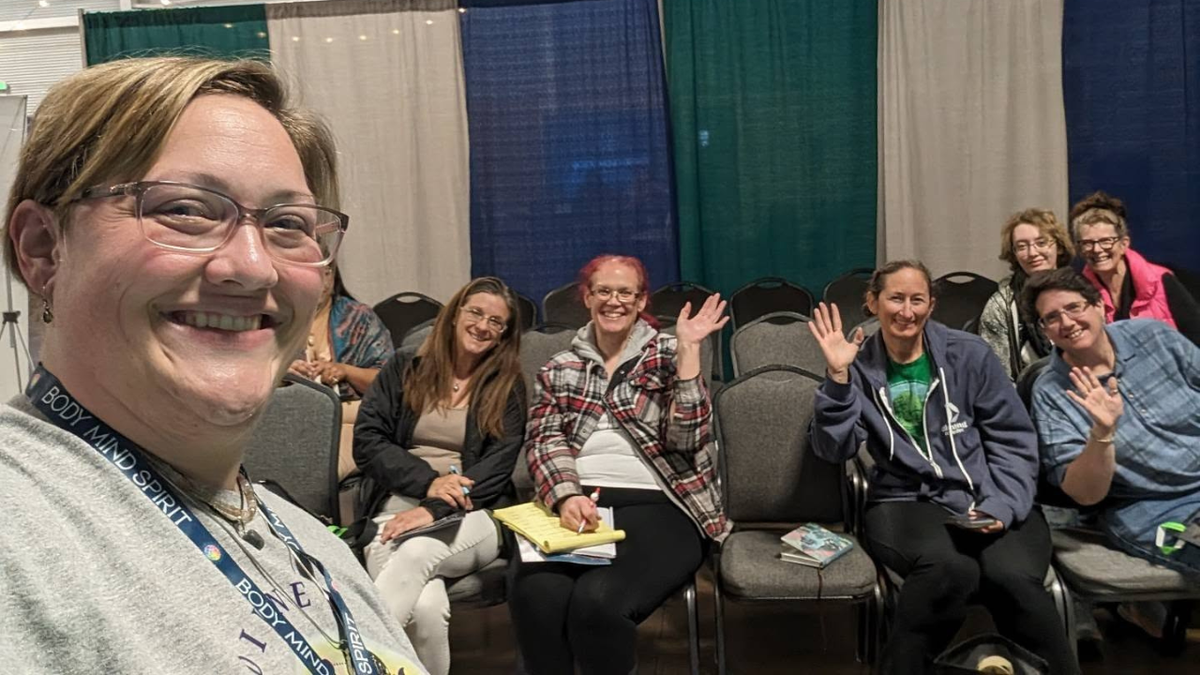 Cassie smiling with participants at a welcoming group gathering